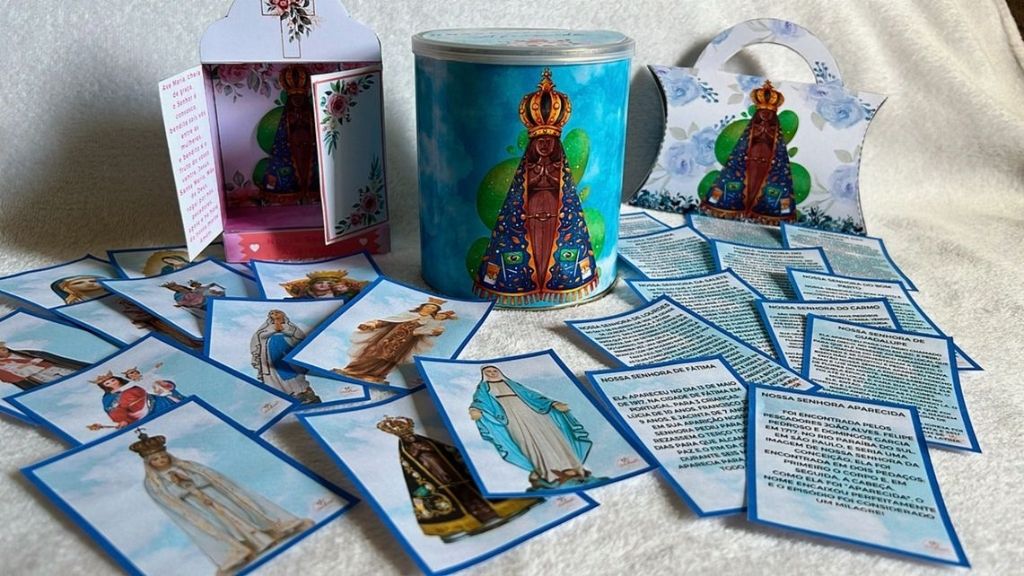 Material impresso e montado: fichas dos títulos de Maria, lata decorada de Nossa Senhora Aparecida e lembrancinhas